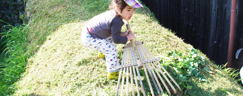 刈った草と格闘中の孫